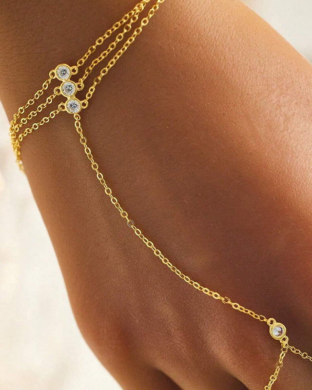 Brățară hand chain aurie cu zirconii purtată pe mână